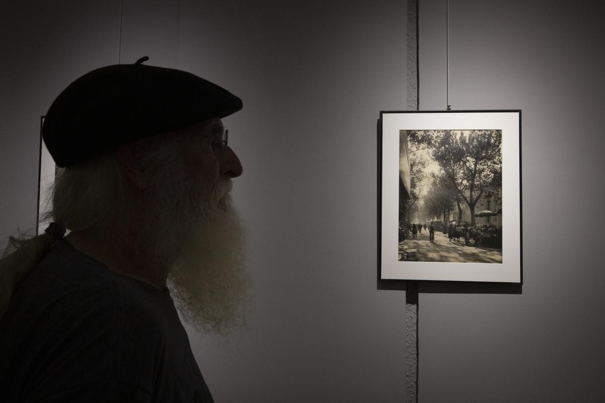 Un aficionado a la fotografía, ante la imagen retratada y revelada por Català-Roca de la Rambla de Barcelona