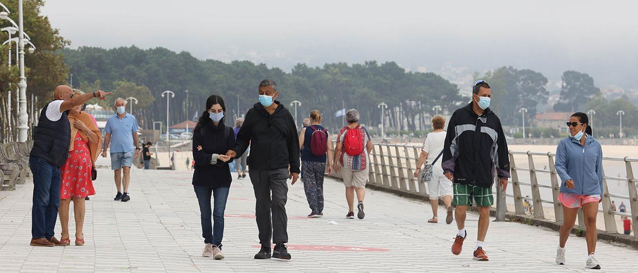 Personas con y sin mascarilla el primer día de la norma que permite no llevarla en exteriores.