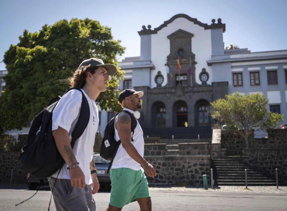 Dos jóvenes pasan frente al Campus Central de la Universidad de La Laguna.  | ANDRÉS GUTIÉRREZ