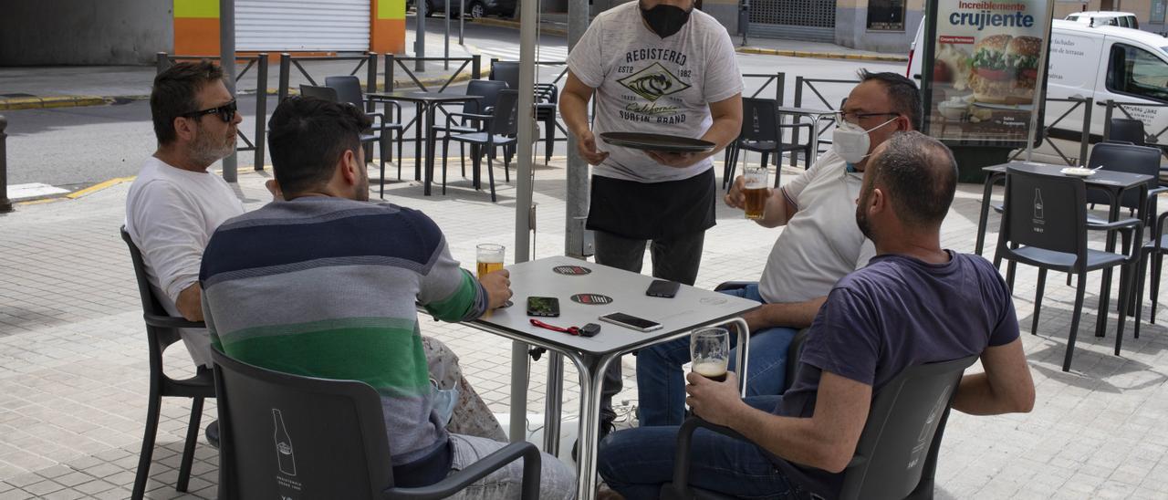 Un camarero atendiendo a unos clientes en un bar de Xàtiva.
