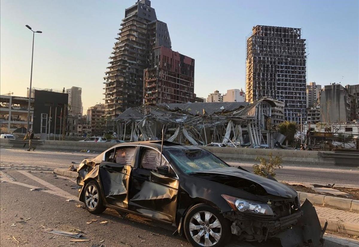 Un coche y edificios dañados por la explosión.