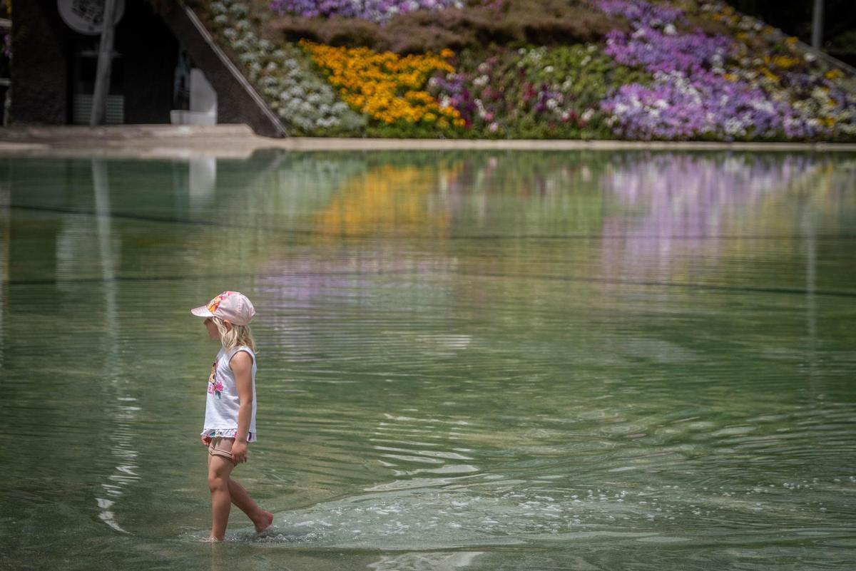 Una niña se refresca en la charca de la Plaza de la Candelaria, en Santa Cruz.