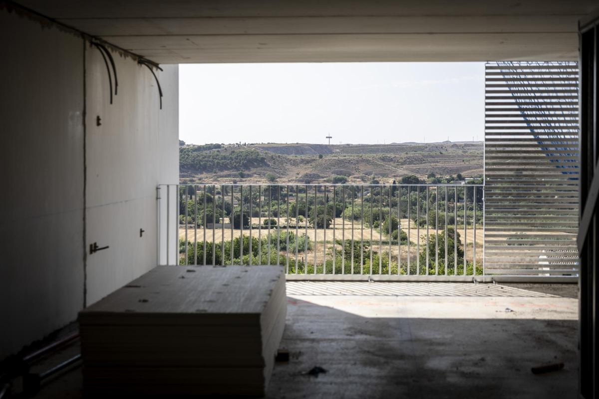 El salón comedor de una de las viviendas de una habitación, con vistas a la estepa zaragozana desde el balcón.