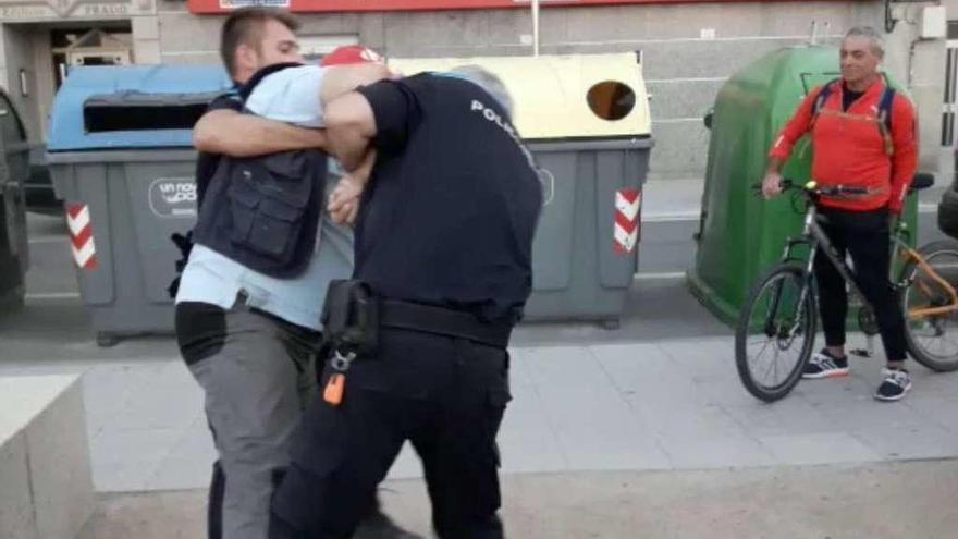 Dos agentes de la Policía Local tratan de reducir al vecino que irrumpió en el concierto. // FdV