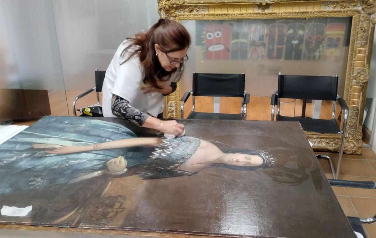 La experta Margarita García Pertejo con el lienzo de «Retrato de la reina Isabel II». | J. N. 