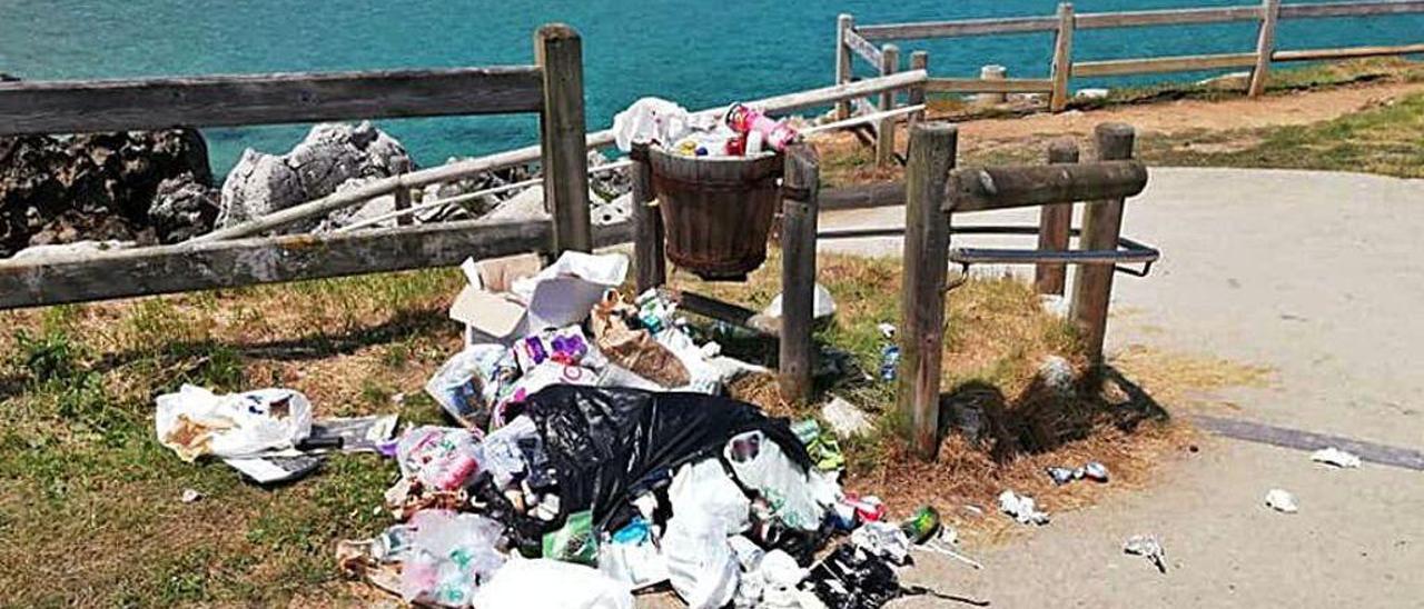 Basura junto a una papelera de la playa de Cue (Llanes).