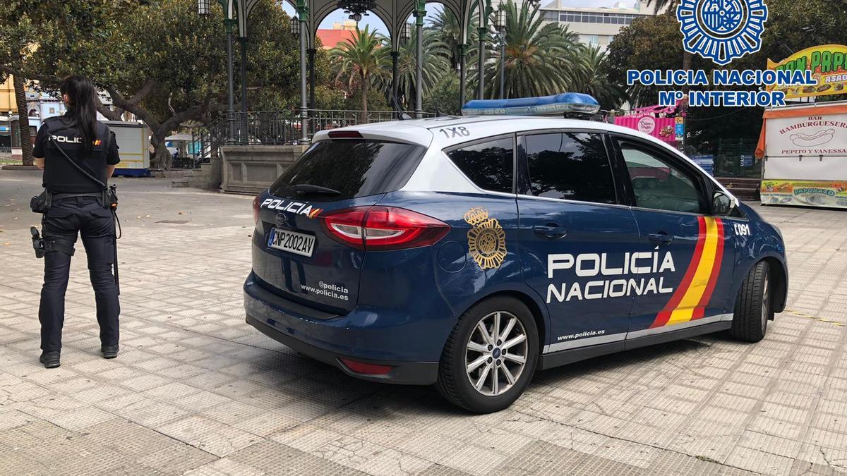 Una agente junto a un vehículo de la Policía Nacional en el Parque de San Telmo.