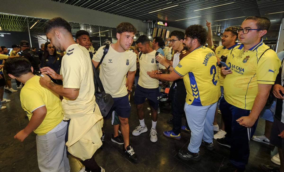 Aficionados reciben a la UD Las Palmas en el aeropuerto tras sellar el playoff