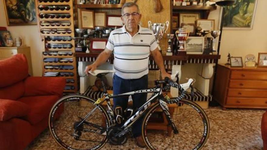 Ismael Calatayud, ayer, en su domicilio con una bicicleta y rodeado de trofeos.