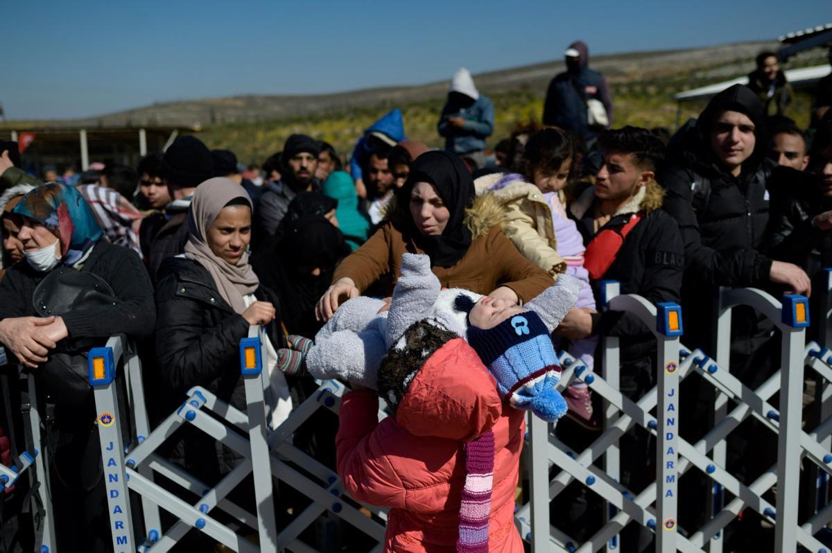 Los residentes sirios de la ciudad de Hatay esperan para cruzar la frontera entre Turquía y Siria después de que se vieron afectados por el terremoto de magnitud 7,8 que asoló la región hace casi dos semanas, en la puerta fronteriza de Cilvegozu