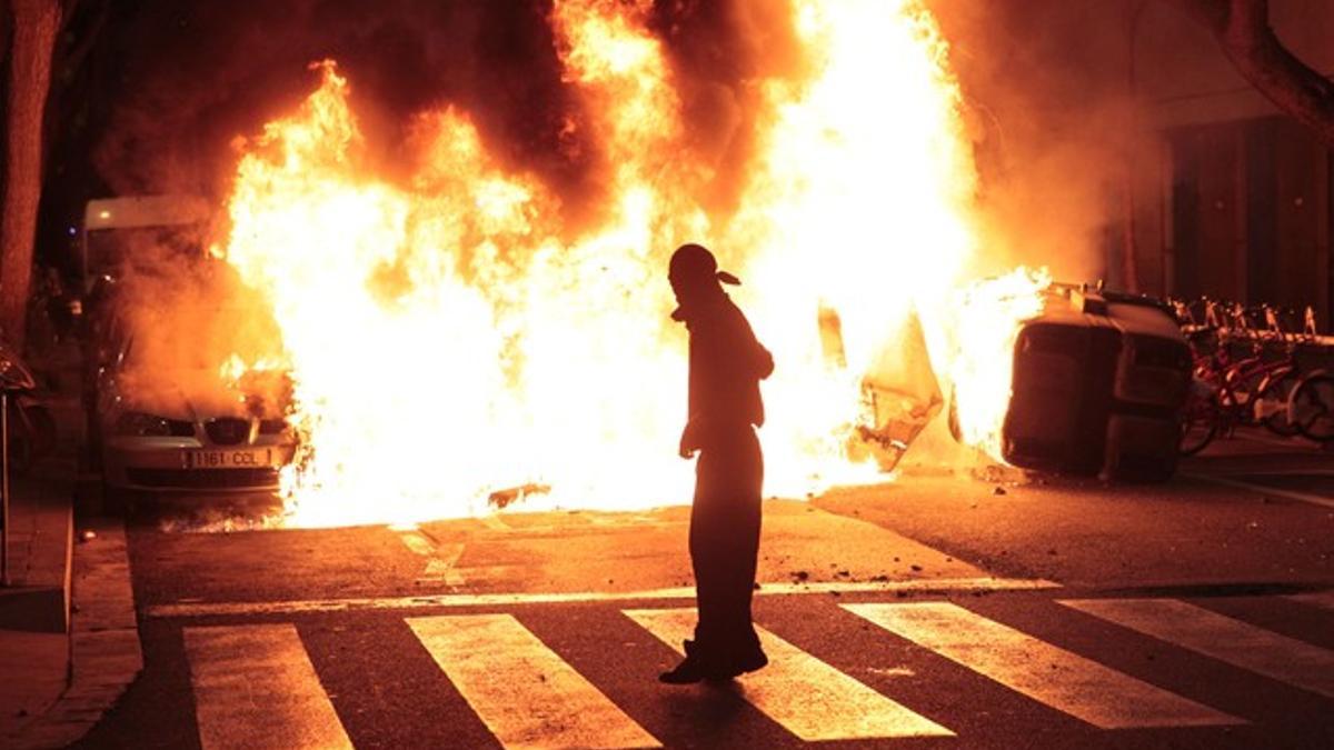 Un vehículo arde durante los disturbios, al final de la rambla del Raval.