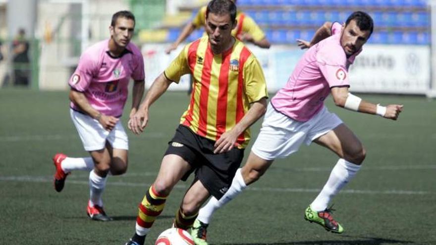 Un jugador del Sant Andreu controla el balón ante dos rivales del Orihuela.