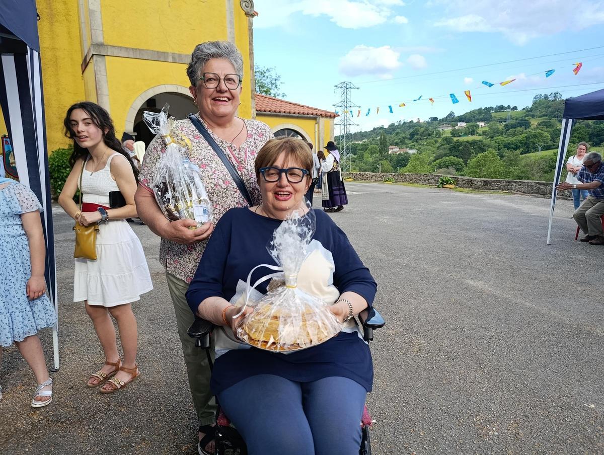 Belarmina y Mari Nieves Montes, con uno de los lotes de la subasta.