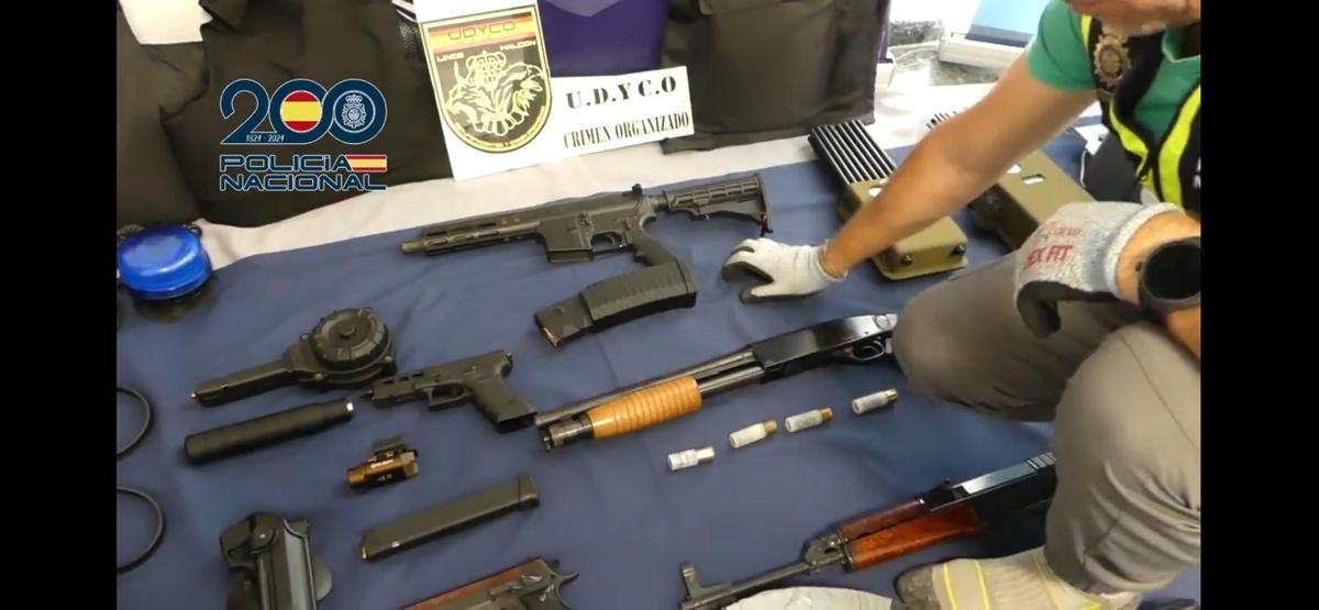 Un agente muestra algunas de las armas intervenidas en la vivienda de Aznalcázar.