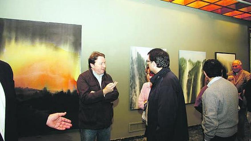 El autor charla con algunos invitados durante la inauguración de la exposición.
