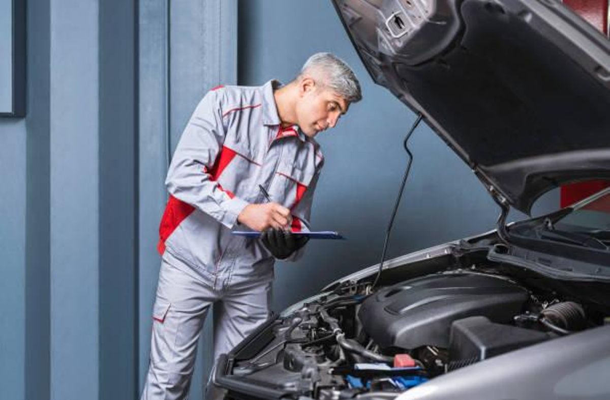 Mecánico revisando el alternador de un coche