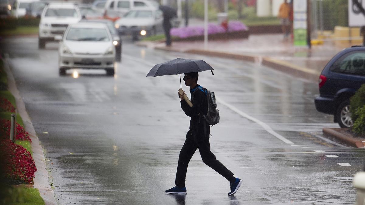 Un hombre se cubre de la lluvia con un paraguas.