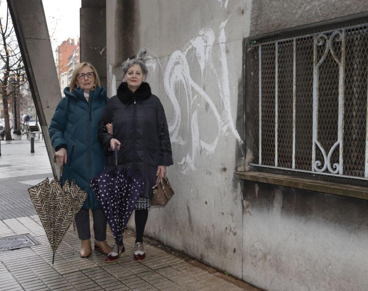 Por la izquierda, Valentina Fernández y Zulma López, junto a una de las pintadas de la fachada de los antiguos juzgados. | LUCAS CID