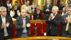 Los diputados del Parlament aplauden en homenaje a Muriel Casals, con una rosa blanca en su escaño.