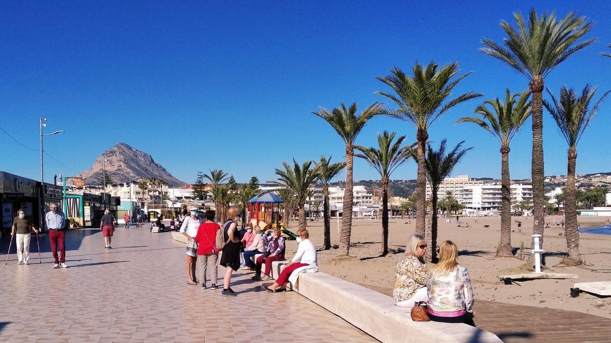 Los vecinos han aprovechado el espléndido día para tomarse el café sentados en el muro del paseo.