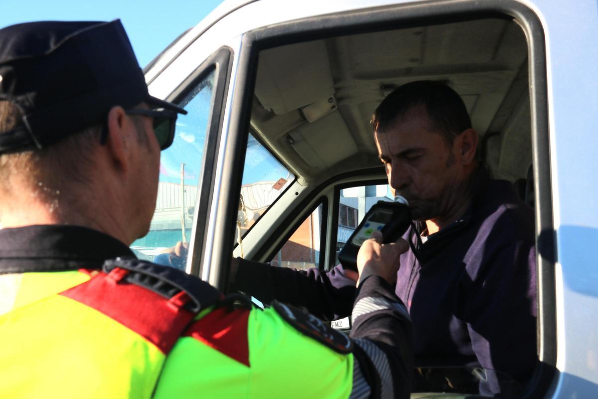 Agent dels Mossos d'Esquadra realitzant prova alcoholèmia a un conductor durant un control, en una foto d'arxiu.