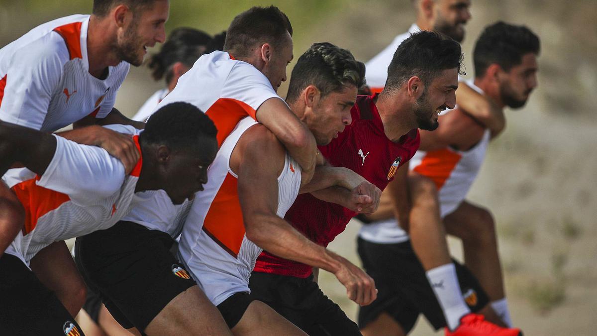 Los futbolistas, ayer, en 
plena carga física en 
la playa.  valencia cf