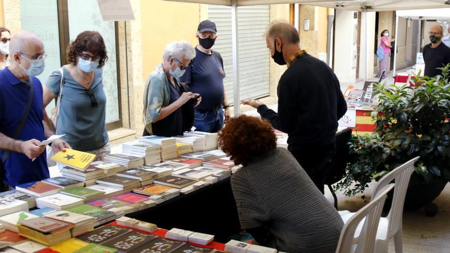 Persones mirant llibres en una parada de la fira, aquest dissabte |