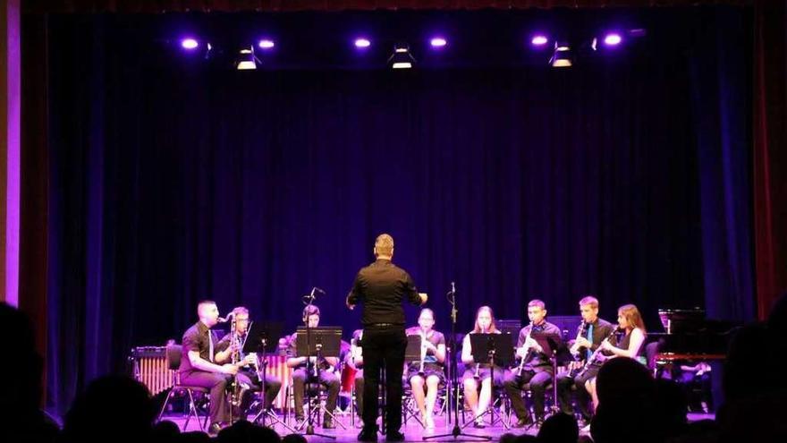 Raúl Azores dirige a los músicos que integran el ensemble de clarinetes durante un concierto.