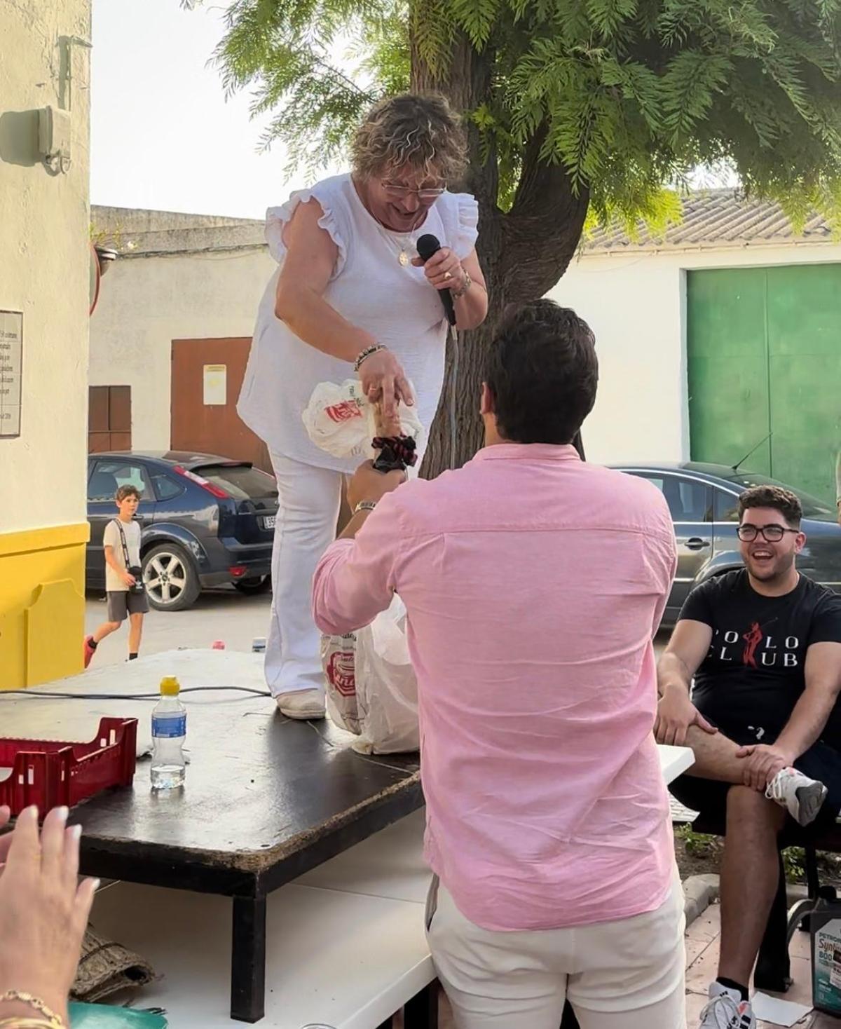 Francisco Carmona, el postor ganador de un jamón, recogiendo su compra.