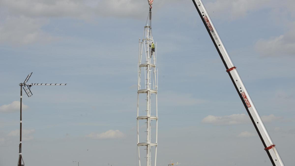Un operario en la antena reitrando las cadenas de sujeción de la grúa que había subido la estructura de cinco toneladas al edificio.
