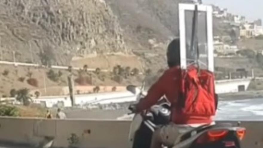 Conducción temeraria en Gran Canaria: un motorista circula con una ventana en la espalda
