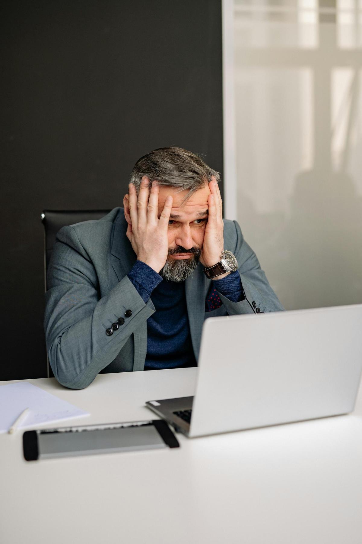 Un hombre consultando algo en el ordenador con preocupación