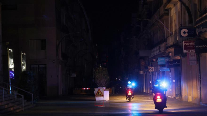 Dos agentes en moto realizan tareas de prevención por el centro de Vigo en medio de la total oscuridad que trajo consigo el apagón eléctrico.