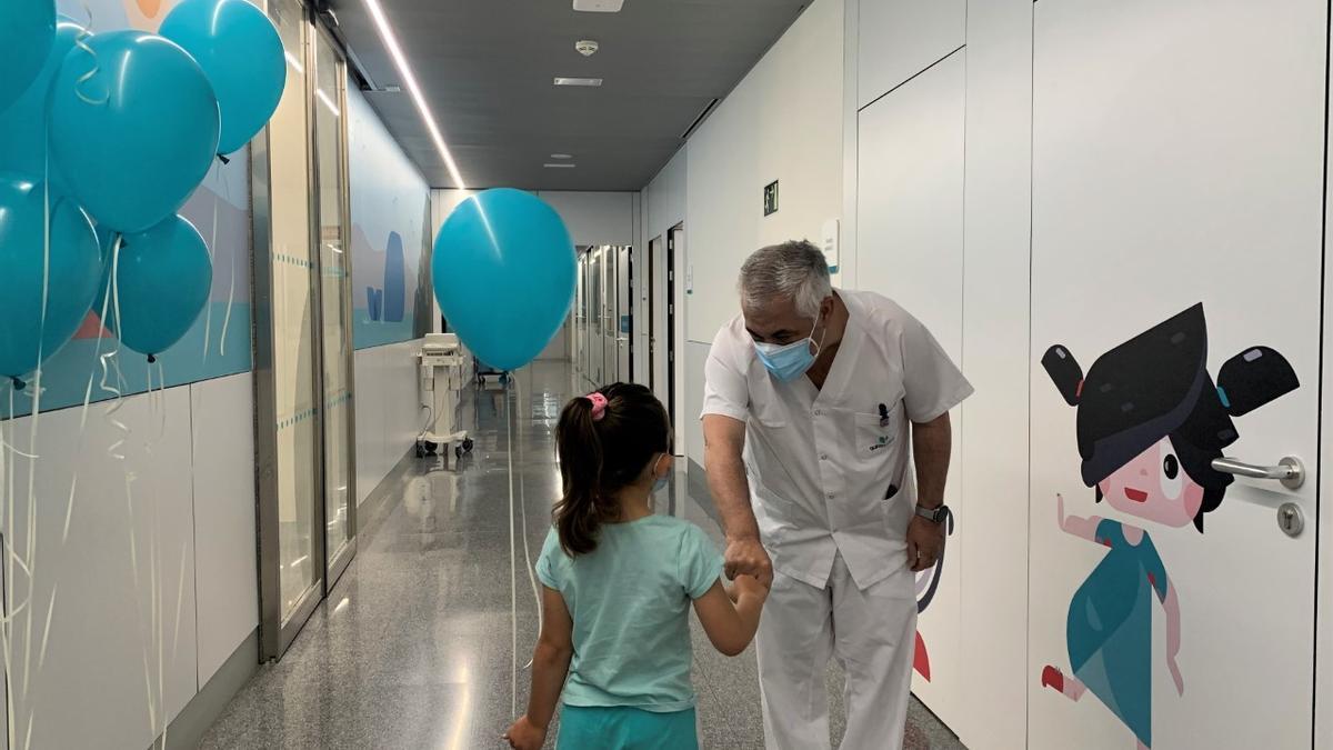 una Una paciente de urgencias pediátricas recibe sus regalos, junto al jefe de servicio de Pediatría, Francisco Javier Baena.