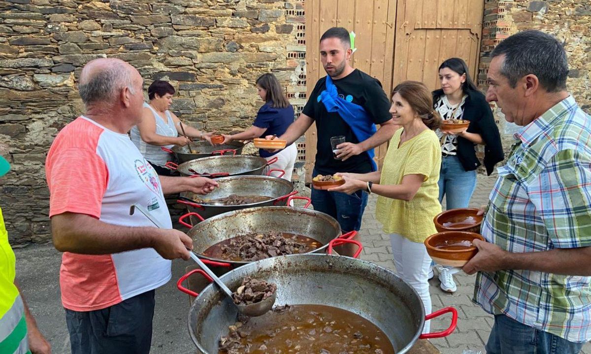 Los vecinos llenan sus platos del rico guiso. | Ch. S.