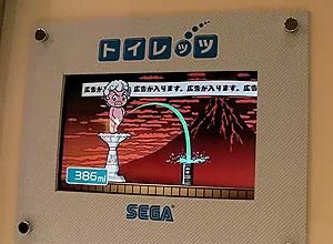 Estand promocional de la firma Sega, on es veu el funcionament del joc ’Toylet’.