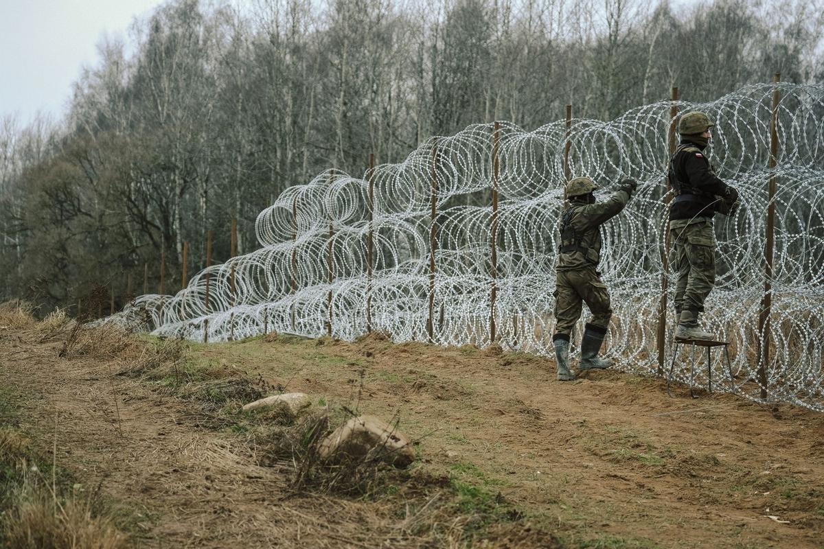 Soldados del ejército polaco arreglan bobinas de alambre de púas en una valla a lo largo de la frontera polaca, con el enclave ruso de Kaliningrado, cerca de Zerdziny, Polonia