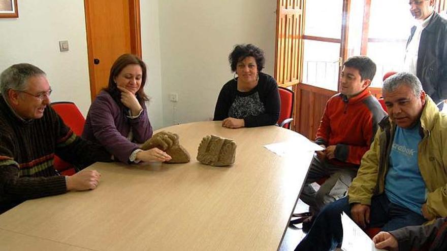 La alcaldesa, la edil de Cultura y los arqueólogos con los fragmentos de la mano y la estela funeraria sobre la mesa