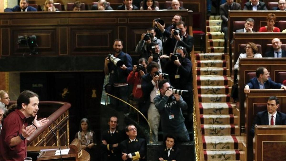 Pablo Iglesias se dirige al hemiciclo en la segunda sesión del debate de investidura con Pedro Sánchez sentado en su escaño.