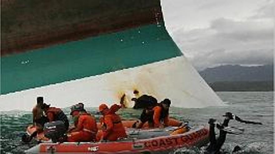 rescate. Un equipo de salvamento halla un cuerpo cerca del barco, ayer.