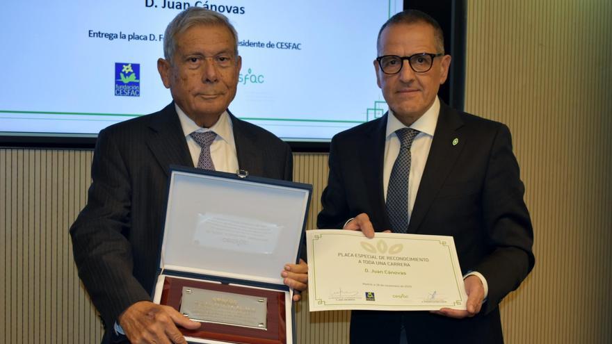 Juan Cánovas (izquierda) recoge la placa de reconocimiento a su carrera.