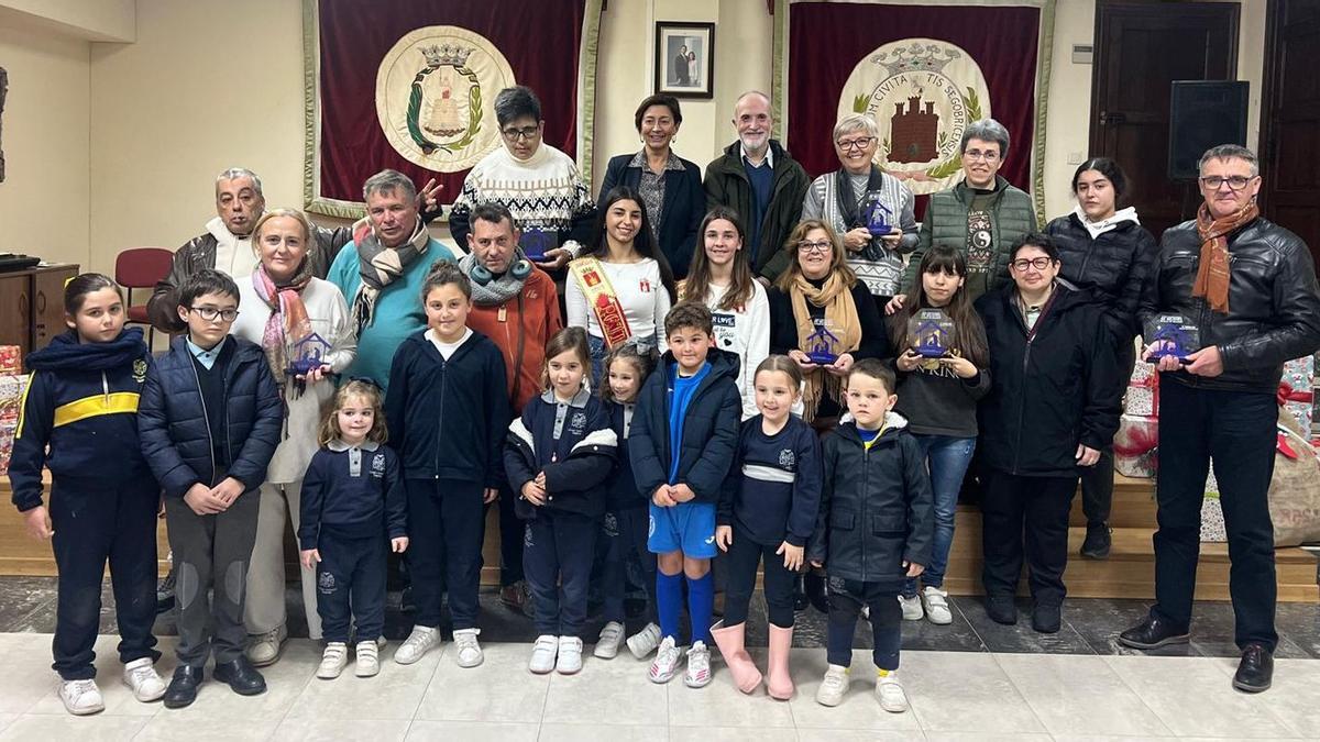 Foto de familia de los premiados en el concurso de Belenes, junto a las autoridades locales, encabezadas por la alcaldesa, Mª Carmen Climent.