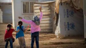 Tres niños, en un campamento de refugiados.