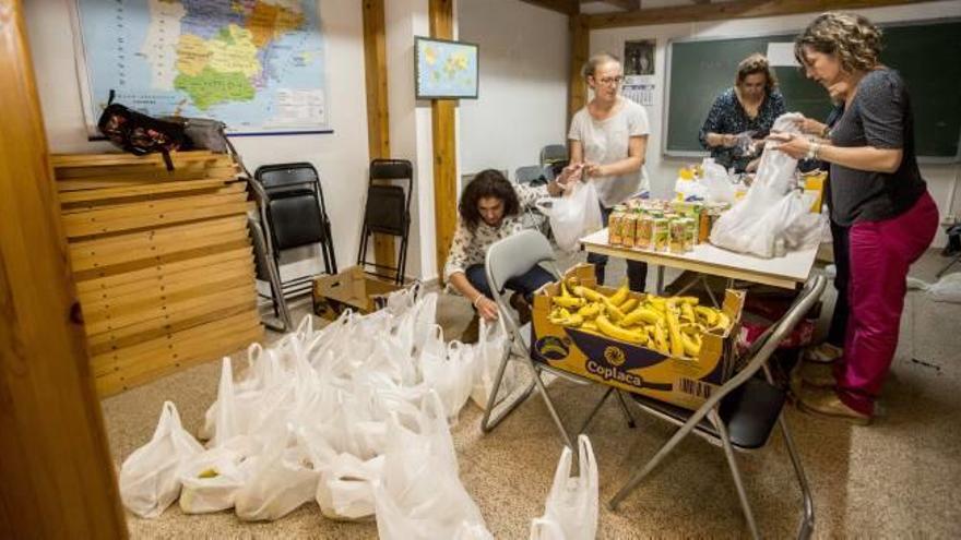 Las bolsas para los indigentes se preparan en un local de Cáritas en Sant Joan.