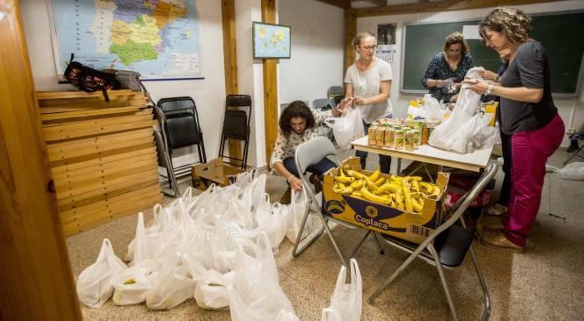 Las bolsas para los indigentes se preparan en un local de Cáritas en Sant Joan.
