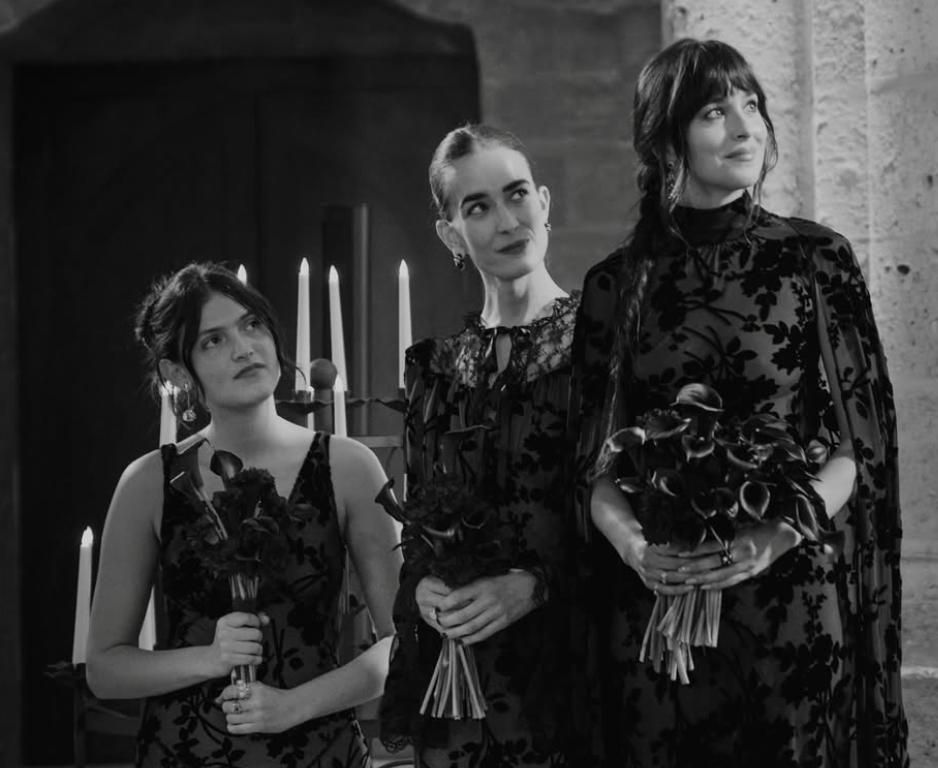 Dakota Johnson (derecha) mirando atentamente a la pareja