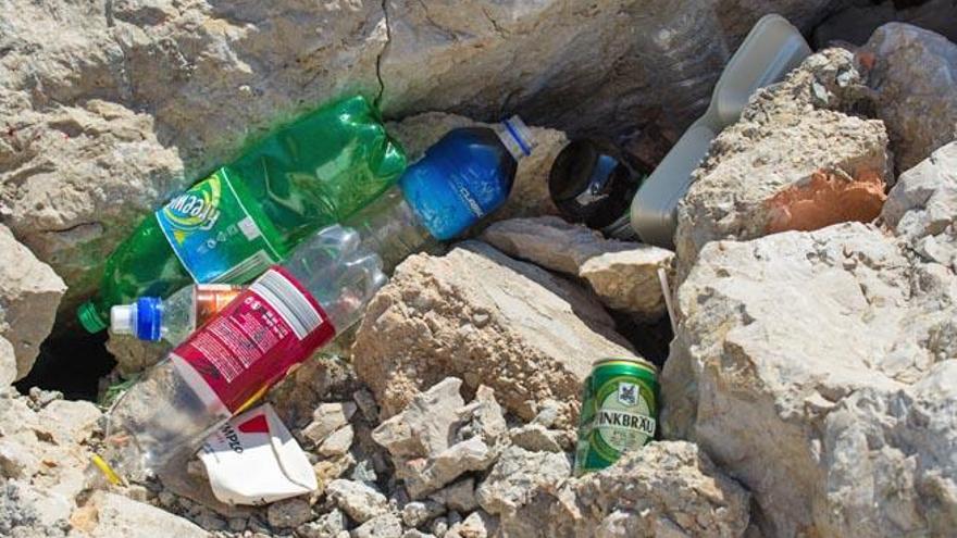 Envases de bebidas alcohólicas, de refrescos y de agua tirados en las rocas del espigón del puerto, el pasado sábado.