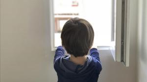 Un niño de cinco años mira por la ventana de su casa en Madrid, de la que no sale desde el pasado 11 de marzo.