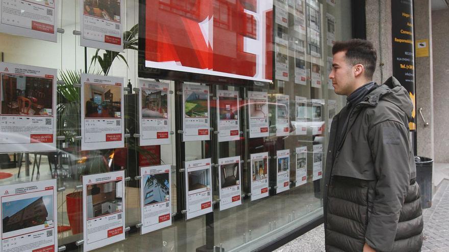 Un joven mira las ofertas de pisos en el escaparate de una inmobiliaria. |   // IÑAKI OSORIO