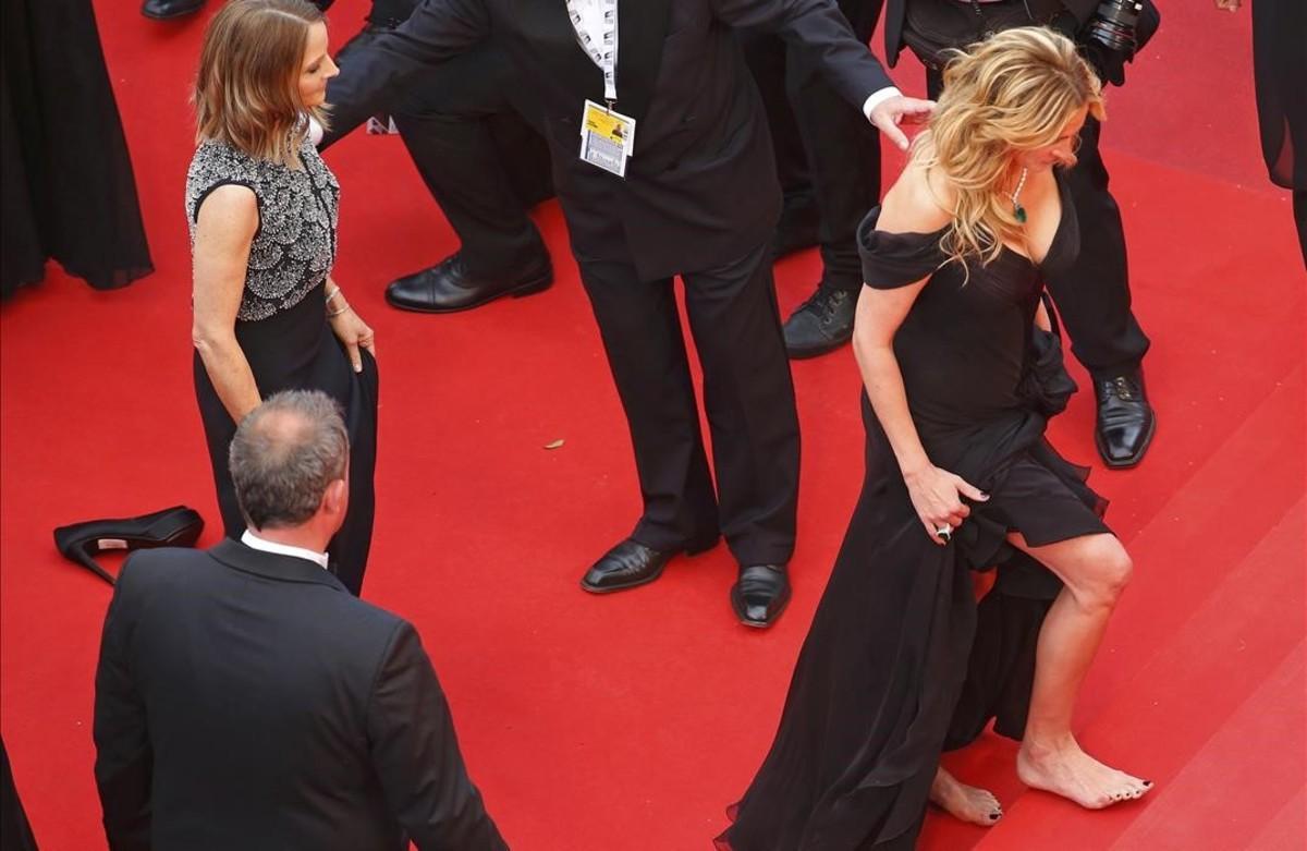 Julia Roberts camina descalça sobre l’alfombra vermella.